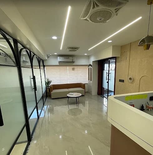 Waiting area at V-Dent Dental Care with seating, and glass-partitioned treatment rooms alongside
