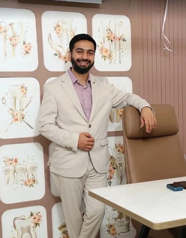 Dr. Vijay Makwana, dentist at V-Dent Dental Care, standing in the consultation room in New Nikol, Ahmedabad